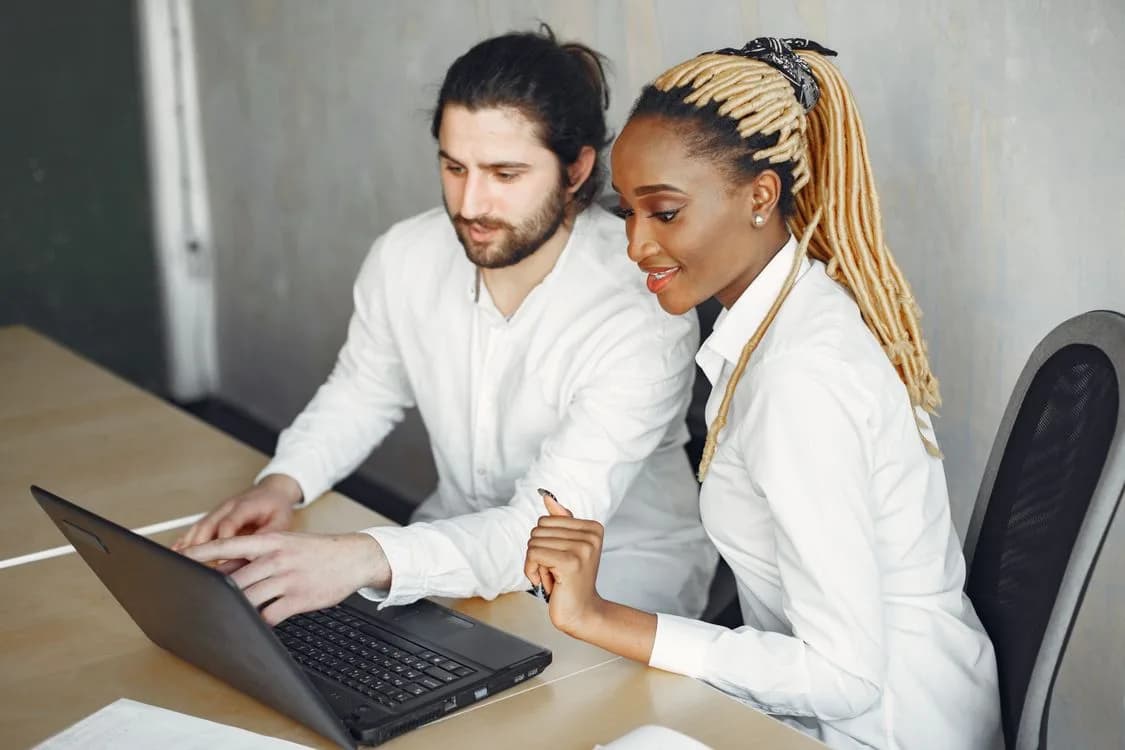 Two professionals working together on a laptop